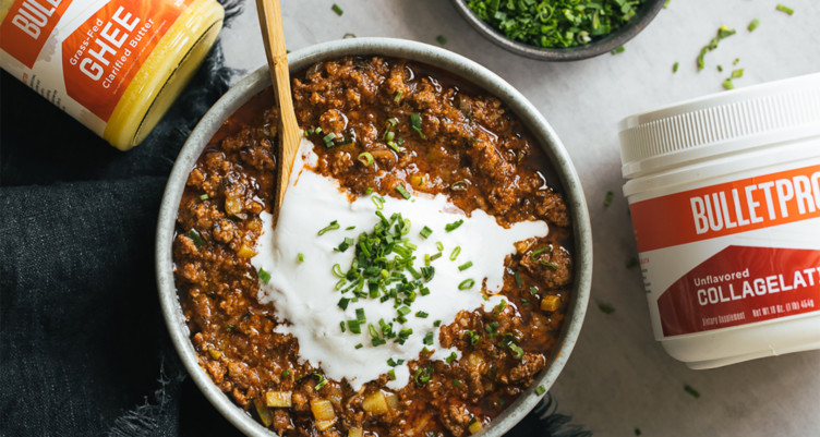 bowl of chili topped with cream and herbs